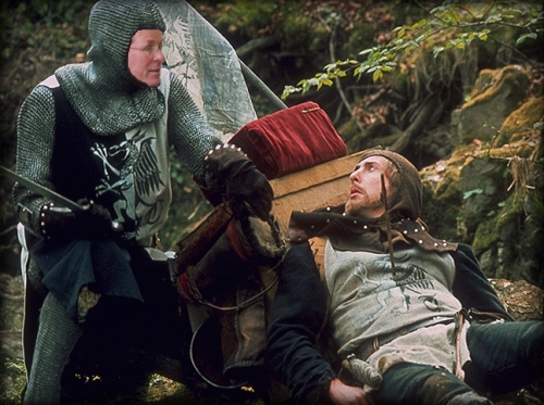 Governor Kulongoski as a knight looking down at his squire who has an arrow in his chest